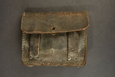 an old brown leather case with two compartments on a table