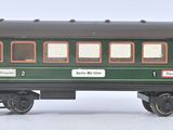 a green train car that is sitting on a white surface