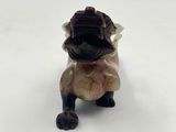 a close up of a figurine of a dog on a white surface