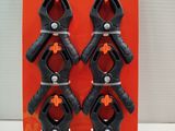 four black and orange spring clamps in a package