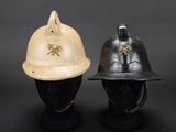 two helmets are sitting next to each other on a black surface