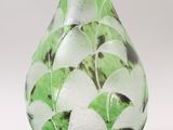 a glass vase with a green and white design on it