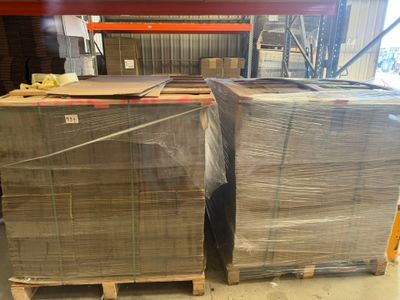 deux palettes de cartons posées sur des palettes dans un entrepôt