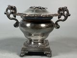 a silver bowl with a lid on a stand