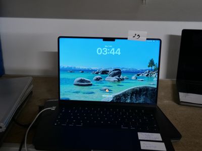 a laptop that is sitting on a desk with a clock on the screen