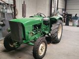 un tracteur vert garé à l'intérieur d'un bâtiment