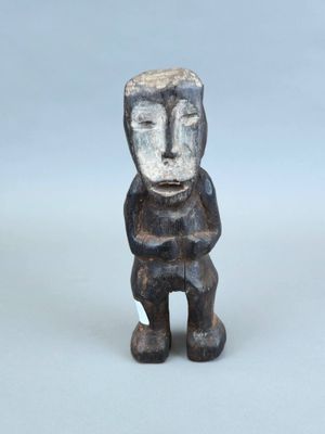 une image représentant une petite statue d'un homme posée sur une surface blanche