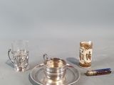 a silver plate with a silver cup and saucer on it