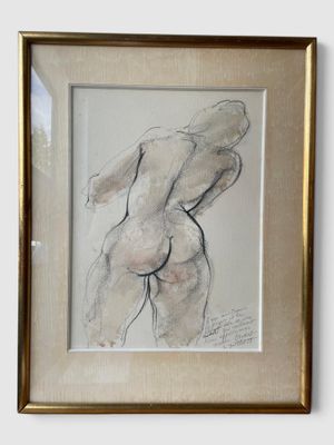 tableau représentant une femme nue, dans un cadre doré, accroché à un mur blanc
