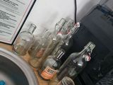 many bottles of alcohol on the counter next to a coffee machine