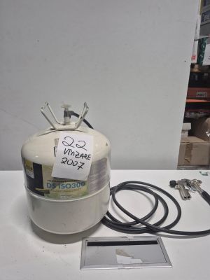une bouteille de propane, munie d'un tuyau, posée sur une table