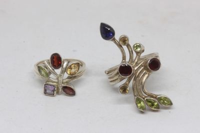 a pair of earrings with multi colored stones on a white surface