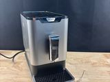 a silver coffee machine sitting on top of a wooden table