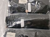 four bags of black clothing sitting on a table