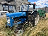 un tracteur bleu qui est garé dans l'herbe