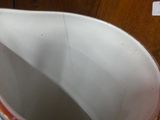 a white pitcher sitting on top of a table next to a cup