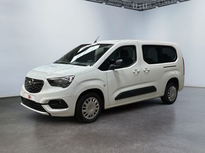 La camionnette blanche est garée dans une grande pièce blanche.
