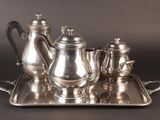 a silver tea set on a tray on a table