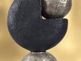 a sculpture of a black and silver object on a table