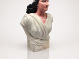 a white busturine of a woman with a pink flower in her hair