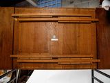 a man that is standing next to a wooden cabinet