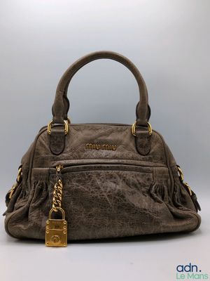 un sac à main marron muni d'un fermoir doré sur la poignée