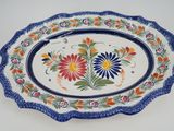 a plate with a flower design on it sitting on a table