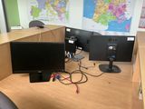 a desk with two monitors and a keyboard on it