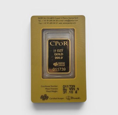 un lingot d'or dans un emballage posé sur une surface blanche