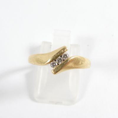 bague en or jaune sertie de deux diamants sur une surface lisse