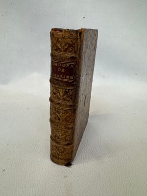 un vieux livre posé sur une surface blanche