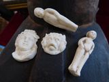 a statue of a man and three figurines sitting on a table