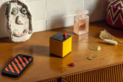 a cell phone sitting on a wooden table next to a vase