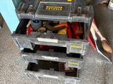 une boîte à outils contenant des outils, posée sur le sol