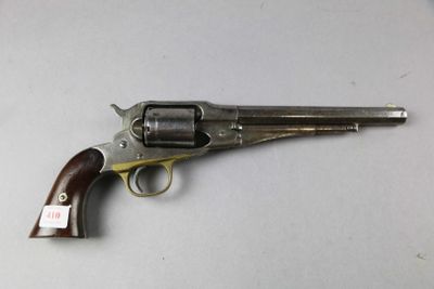 un gros plan d'un revolver posé sur une table, sur fond blanc