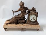 a statue of a woman sitting on a table with a clock