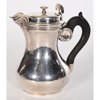 une cafetière ancienne en argent avec une poignée noire sur fond blanc