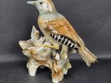 a figurine of a bird sitting on a branch