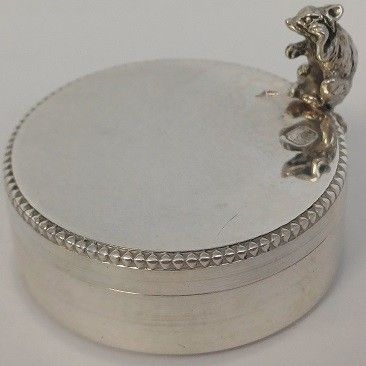 un plat ancien en argent sur lequel est perché un oiseau
