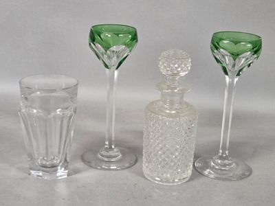 three wine glasses and a decanter sitting on a table