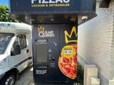 un camion de livraison garé devant une pizzeria