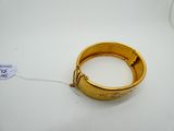 an image of a gold ring on a white surface with a tag on it