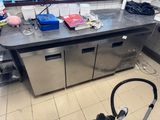stainless steel counter top in a commercial kitchen with a vacuum on the floor