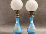 une paire de lampes en verre bleu et blanc posées sur une table