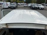 cars are parked in a parking lot with a white truck in the foreground