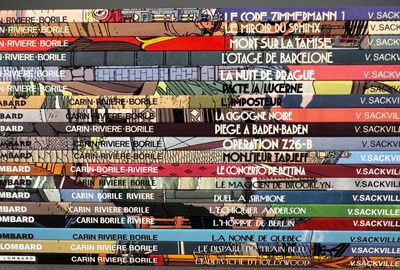 many books stacked on top of each other on a shelf