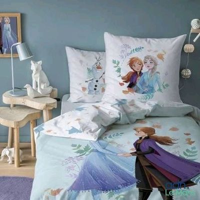 un lit avec deux oreillers et une taie d'oreiller ornée d'un motif représentant des personnages de Disney