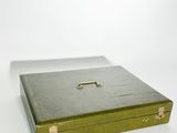 une boîte verte munie d'un cadenas, posée sur une surface blanche