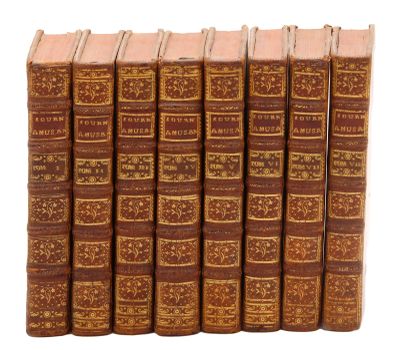 six vieux livres alignés sur une surface blanche