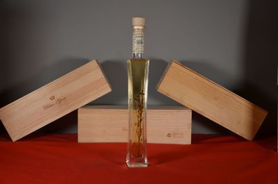 a bottle of liquor sitting on a table next to wooden boxes